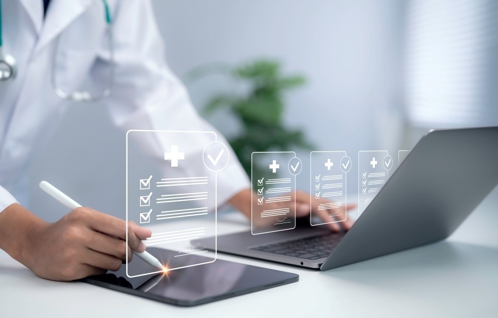 Medical professional checking data with laptop and tablet